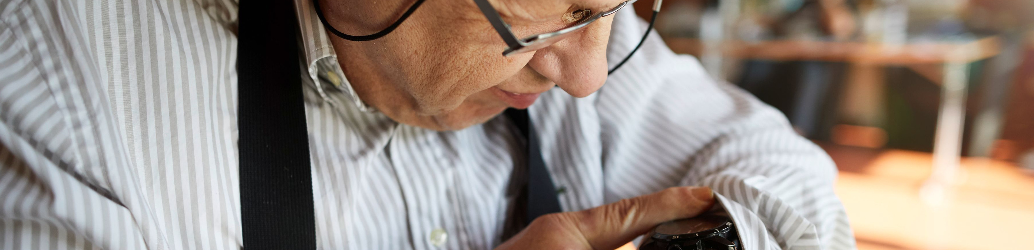 Mann schaut auf seine Armbanduhr. © Lebenshilfe - David Mauer Mann schaut auf seine Armbanduhr