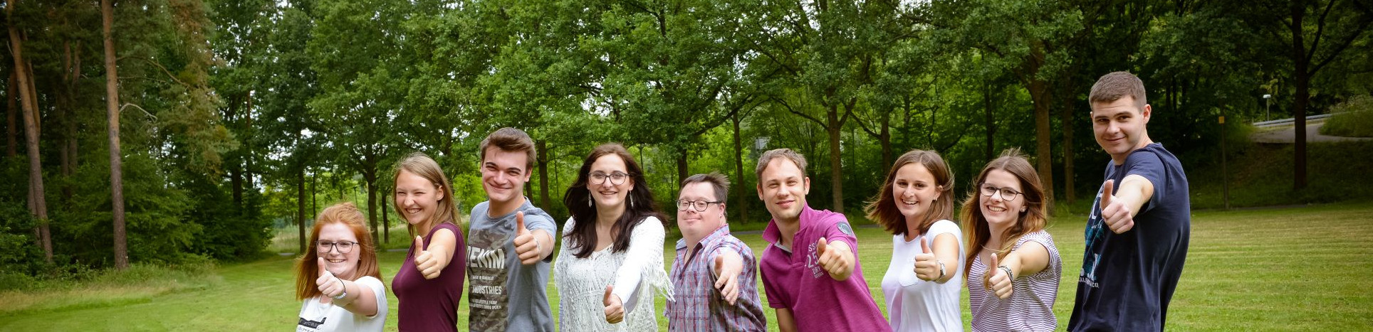 Junge Menschen machen Daumen hoch.