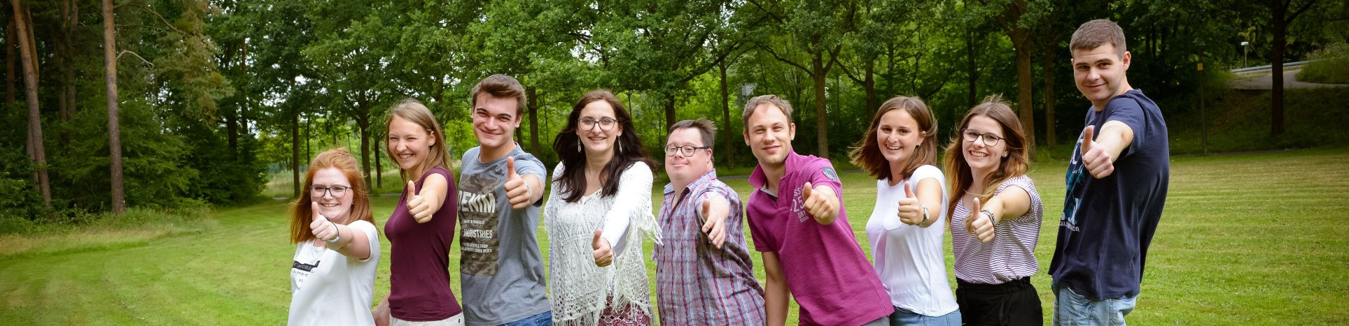 Junge Menschen machen Daumen hoch.