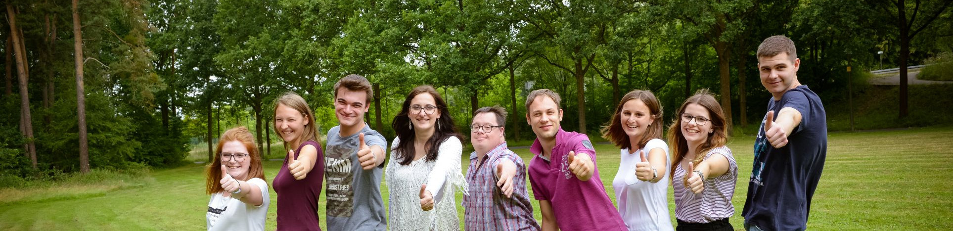 Junge Menschen machen Daumen hoch.
