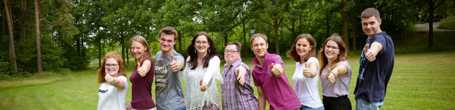 Junge Menschen machen Daumen hoch.