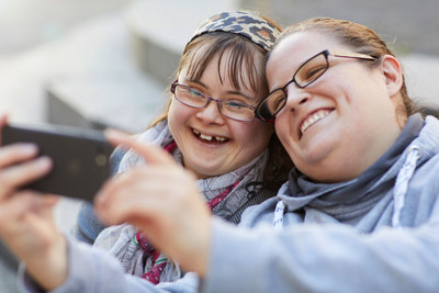 Zwei junge Frauen schauen auf ein Mobiltelefon.